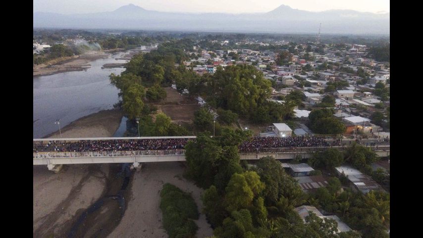 Migrants ford river from Guatemala to Mexico